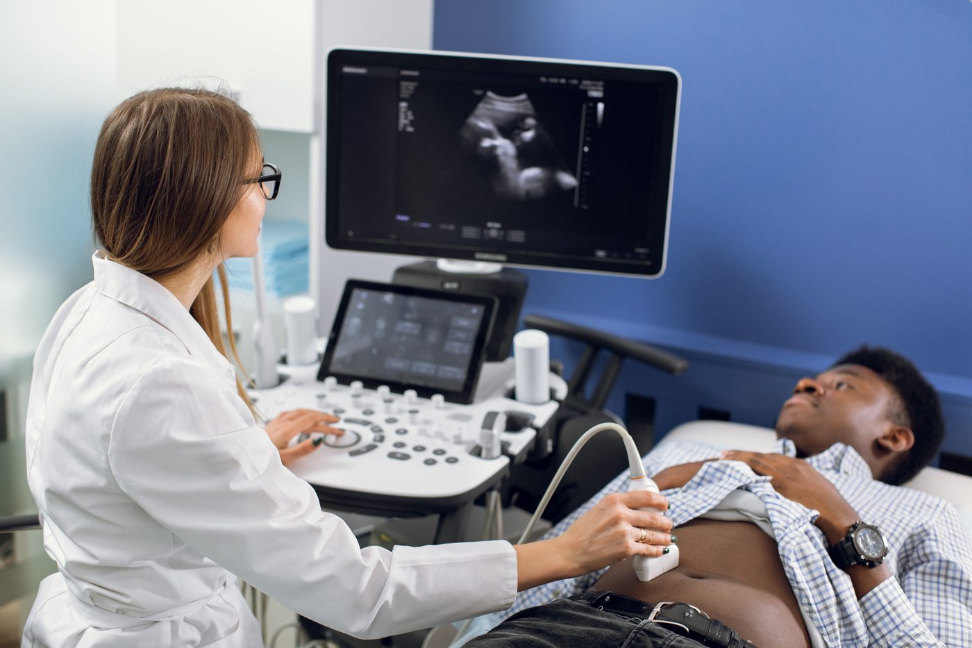Esecuzione di un'ecografia prostatica sovrapubica: la sonda appoggiata sull'addome del paziente